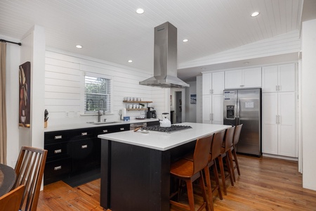 Bright, modern kitchen with stainless appliances, spacious island seating, and plenty of room for family meals or entertaining.