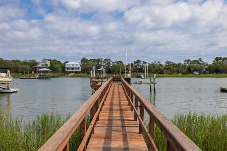 A private dock extends across tranquil waterfront views, offering direct access to the surrounding natural landscape and neighboring properties along the shoreline.