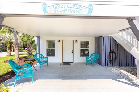 Underneath the Sandy Cheeks Beach House sign, you'll find your covered patio with entry to the downstairs living space