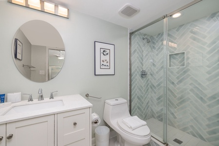 Your bright bathroom features a stylish herringbone-tiled shower and modern vanity for refreshing morning routines.