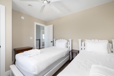 Rest peacefully in your cozy twin bedroom, featuring comfortable beds with fresh linens and gentle ceiling fan breeze.