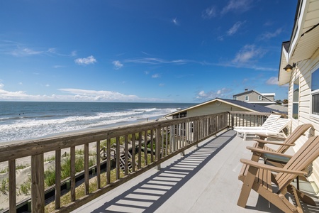 Your private deck stretches before you, sunlit and serene, with loungers perfectly positioned for gazing at the endless waves rolling onto the sandy shore.
