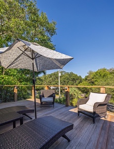 Sunny deck with comfortable lounge seating and umbrella shade — ideal for soaking up the Folly Beach sunshine or relaxing under the stars.
