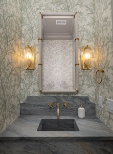 Indulge in your private powder room featuring botanical wallpaper and luxurious marble vanity with brass fixtures.