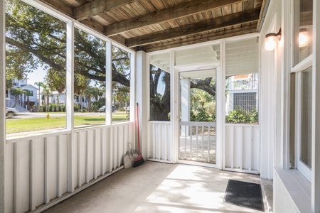 Take the sunlit screened-in porch to your front door