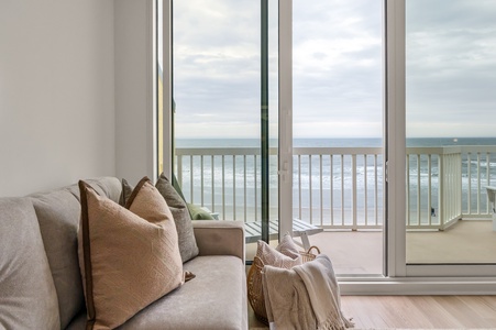 Sink into plush seating while ocean waves dance outside your floor-to-ceiling windows—your perfect beachfront retreat awaits.