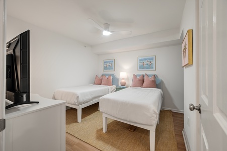 Drift off peacefully in your twin bedroom featuring crisp linens, coastal artwork, and a flat-screen TV for relaxed evenings.