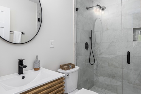 Your updated bathroom featuring single vanity, walk-in glass shower
