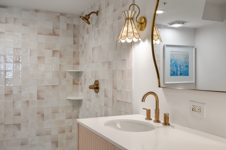Step into your elegant bathroom with gleaming brass fixtures, designer tile work, and a luxurious rainfall shower that promises pure relaxation.