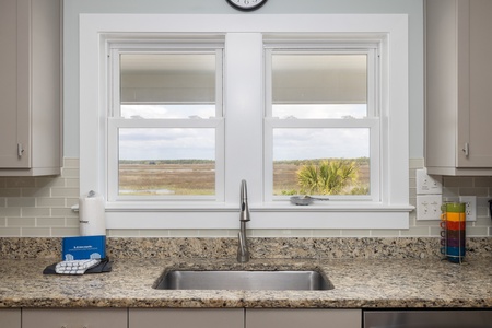 Cook with peaceful wetland views from your kitchen window, where granite counters and modern appliances meet serene natural beauty.