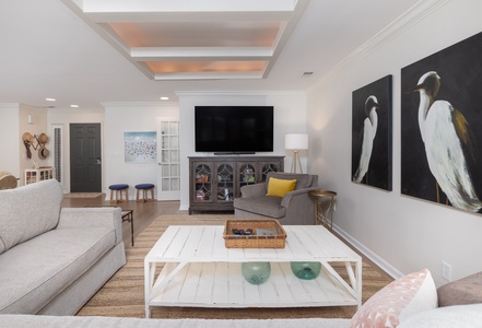 Unwind in your stylish living space with cathedral ceilings, curated art, and cozy seating perfect for movie nights.