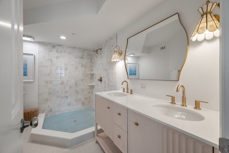 Your updated primary en suite bathroom features an open walk-in shower and large dual vanity