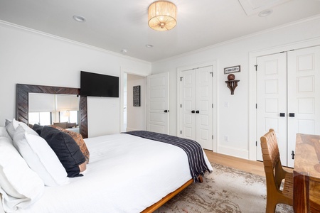 In your second queen bedroom, you'll find warm lighting, coastal decor, and an en suite bathroom