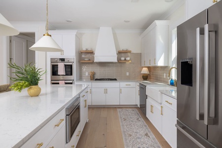 Your gourmet kitchen awaits with gleaming quartz countertops, professional-grade appliances, and elegant gold fixtures for memorable meal preparation.