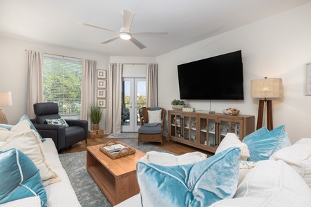 A large, wall-mounted television makes for cozy movie nights