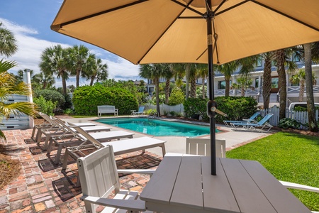 Relax under the umbrella at your poolside table