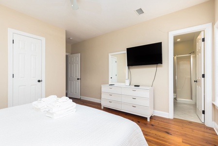 Relax in your spacious master suite featuring warm hardwood floors, a wall-mounted TV for cozy nights, and an ensuite bathroom for ultimate privacy.
