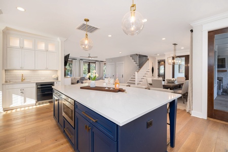 Your gourmet kitchen features a stunning navy island, elegant brass fixtures, and flows seamlessly into the dining and living areas