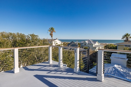 Modern rooftop terrace with sleek railings offers stunning ocean and neighborhood views for relaxing moments.