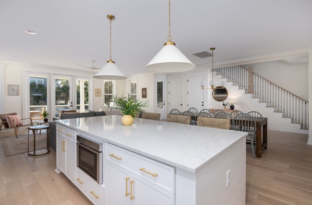 Step into your gorgeous open-concept kitchen where marble countertops and brass fixtures create the perfect space for cooking and entertaining together.