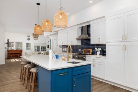 Your kitchen awaits with a stunning blue island and warm lighting