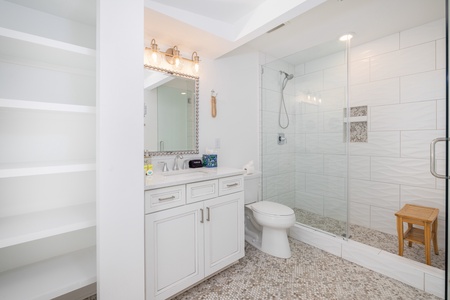 The king en suite bathroom has built-in shelves and a newly updated walk-in shower