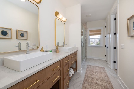 Step into your spa-like bathroom sanctuary with dual vanities, gleaming fixtures, and a luxurious shower waiting to refresh you.