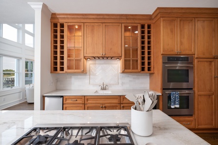 Your gourmet kitchen awaits with marble counters, double ovens, and gas range—perfect for preparing memorable meals while enjoying waterfront views.