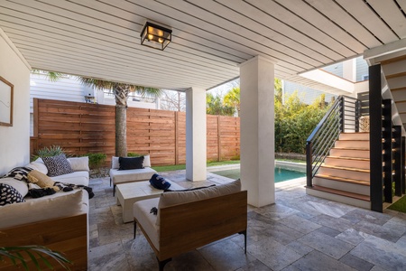 Relax in your private covered patio with stylish seating, overlooking the pool and lush, tropical landscaping