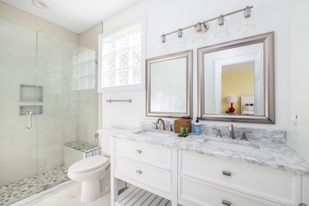 The en suite primary king bathroom features a walk-in shower with built in bench