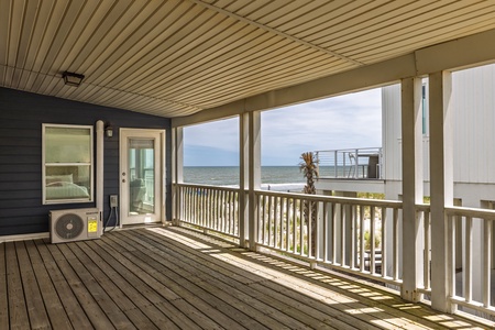 The covered side deck overlooks the ocean and the front of the house