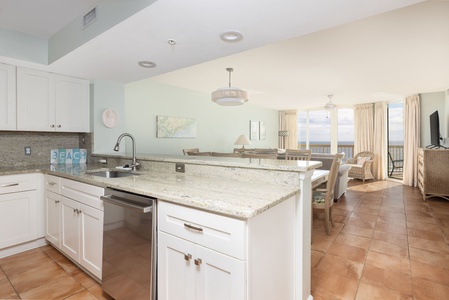 Your open-concept kitchen flows seamlessly into the living space, where granite countertops and modern appliances meet stunning ocean views through floor-to-ceiling windows.