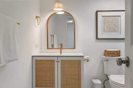 Step into your beautifully appointed bathroom featuring elegant gold fixtures, a stunning arched mirror, and thoughtful touches that make your daily routine feel luxurious.