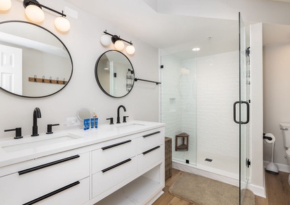 Step into your spa-like master bathroom with dual vanities, modern fixtures, and a luxurious glass-enclosed shower.