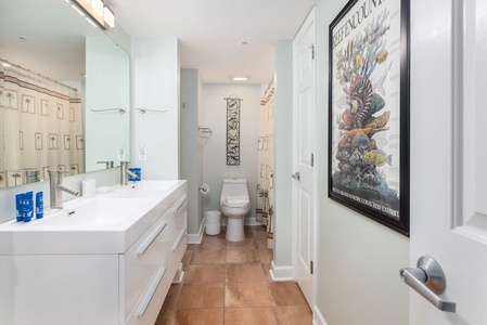 Your sleek modern bathroom features dual vanities, glass shower, and stylish artwork for a spa-like morning routine.