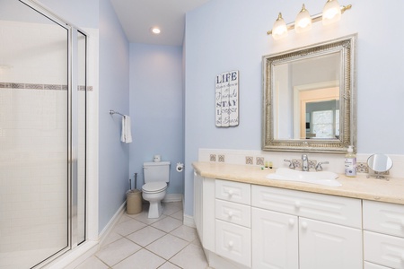 Unwind in your spacious bathroom with dual vanities, elegant mirror, and refreshing glass shower—perfect for your morning routine.