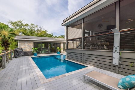 Inviting private pool framed by a modern deck and screened lounge area, blending indoor comfort with outdoor luxury