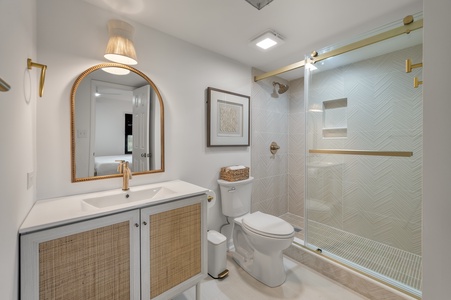 Step into your beautifully appointed bathroom featuring a luxurious herringbone tile shower and elegant gold accents for a spa-like retreat.