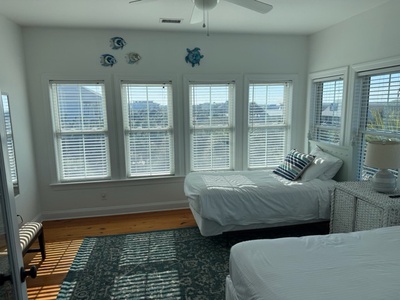 Wake up to stunning water views in your bright, airy bedroom with coastal charm and twin beds perfect for relaxation.