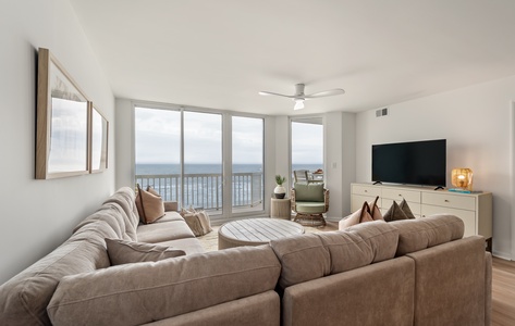 Unwind in your bright living room with plush sectional seating and stunning ocean views through floor-to-ceiling windows.