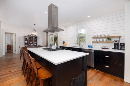 Bright, open kitchen with a large center island, bar seating, and stainless appliances — perfect for cooking and connecting with family after a day on Folly Beach.
