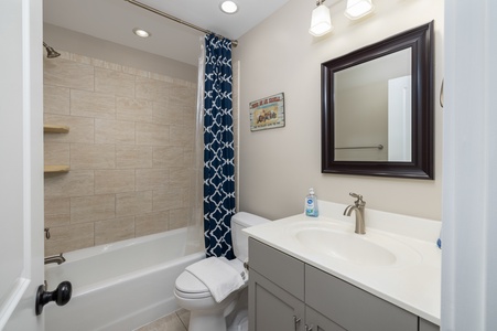Step into your beautifully renovated bathroom with elegant tile work, modern vanity, and thoughtful nautical touches that create a serene retreat.