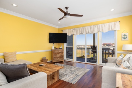 A cozy living room looks out onto your screened in porch and the dock beyond