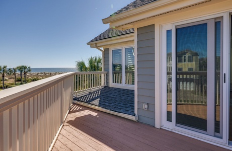 Access your balcony with views of the ocean through your upstairs primary bedroom