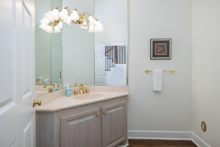 Your elegant powder room features classic finishes, a stylish vanity, and gleaming gold fixtures—a refined space for freshening up.
