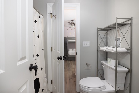 Your bright bathroom features modern fixtures and thoughtful storage, with a playful shower curtain adding personality to your refreshing space.