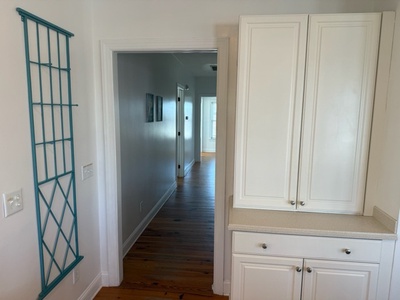 Step into your bright hallway where thoughtful built-ins provide ample storage and a charming teal trellis adds coastal charm to your space.