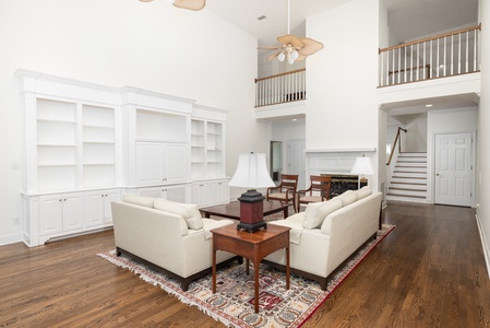 Soaring ceilings and abundant natural light create an airy, elegant living space where you can unwind on plush sofas or gather with loved ones under the gentle breeze of ceiling fans.