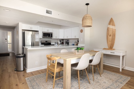 You'll love gathering around this warm wood dining table, sharing meals beneath the stylish pendant light while enjoying the open, airy feel.