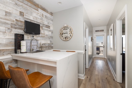 Gather around the stylish breakfast bar with leather stools, where rustic wood accents meet modern convenience.